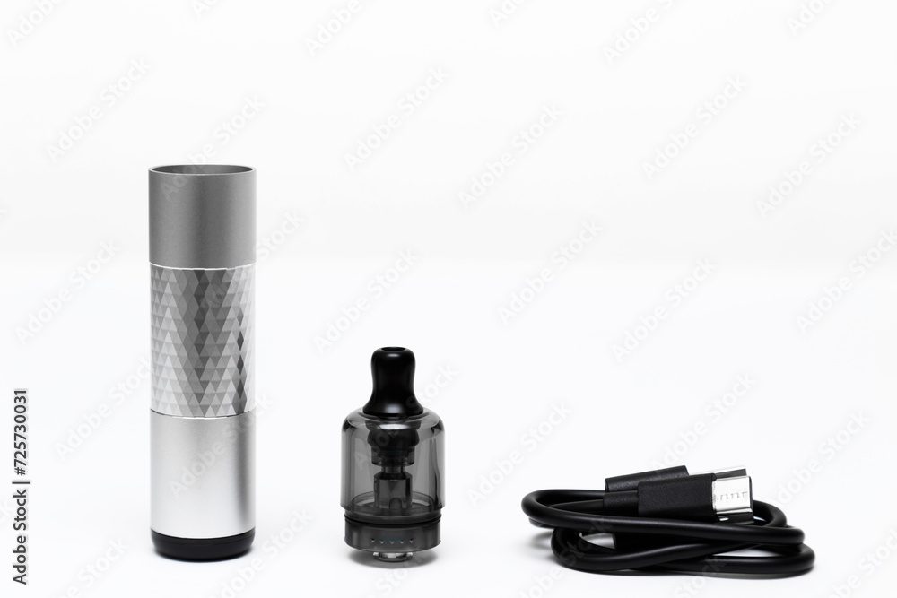 Opened vaping device, vape, pod, kit silver color with charging cable USB Type-C on white background, side view
