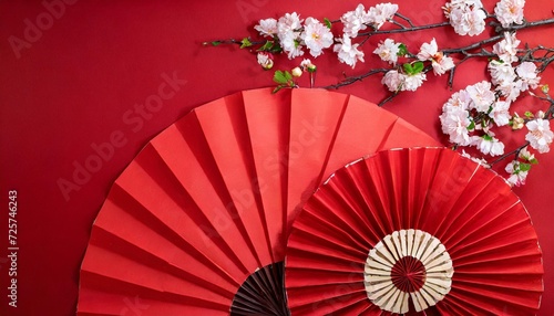 marking chinese new year with a grand celebration top view photo of red paper fans decorative elements sakura on red background with advert panel