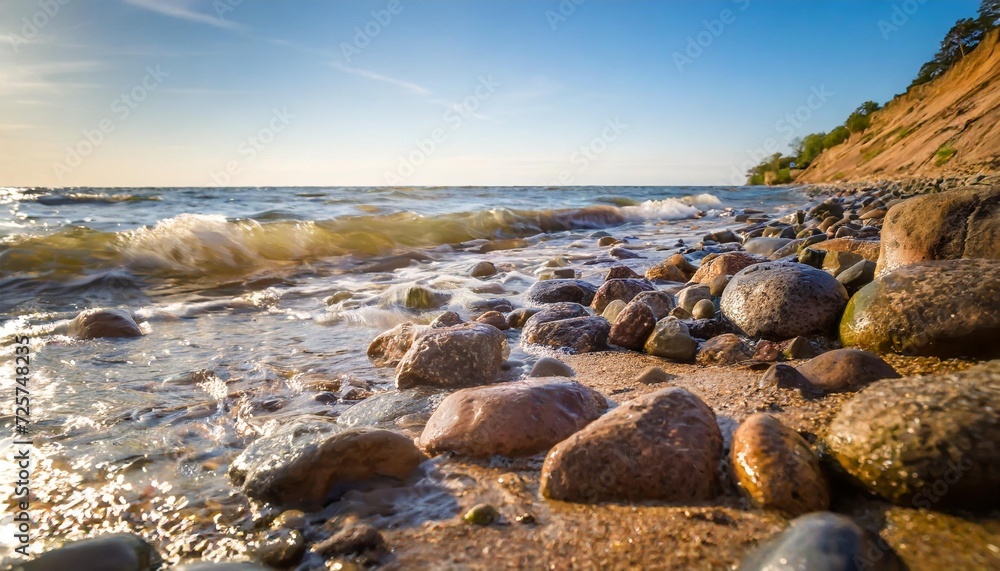 background of sandy stones and flowing waves on the sea beach summer holidays concept