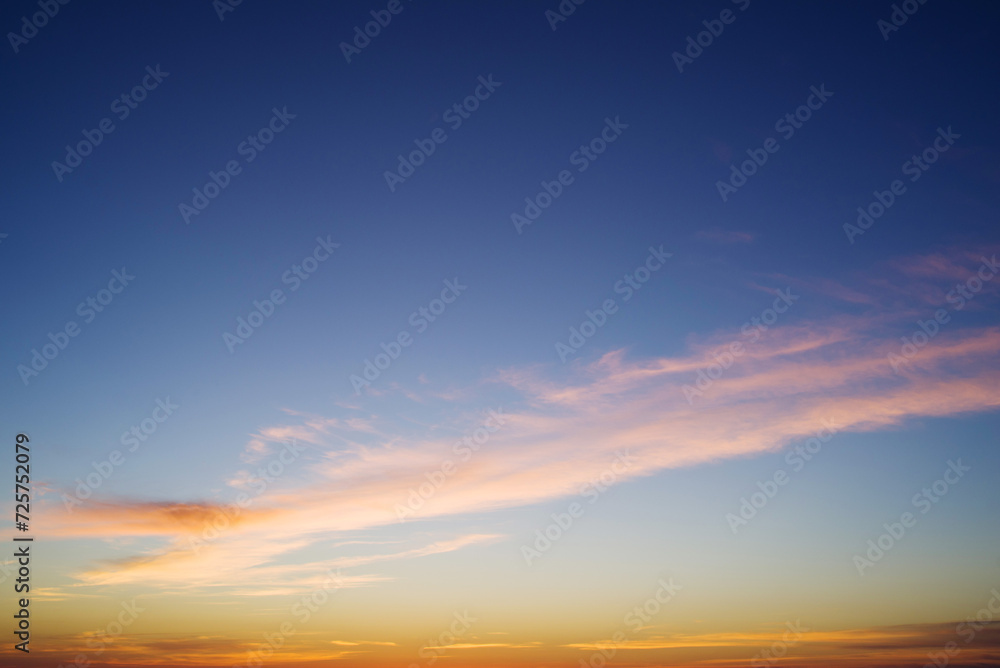 Blue and orange sky background with dark clouds at sunset on a summer evening Blue and orange sky background with dark clouds at sunset on a summer evening
