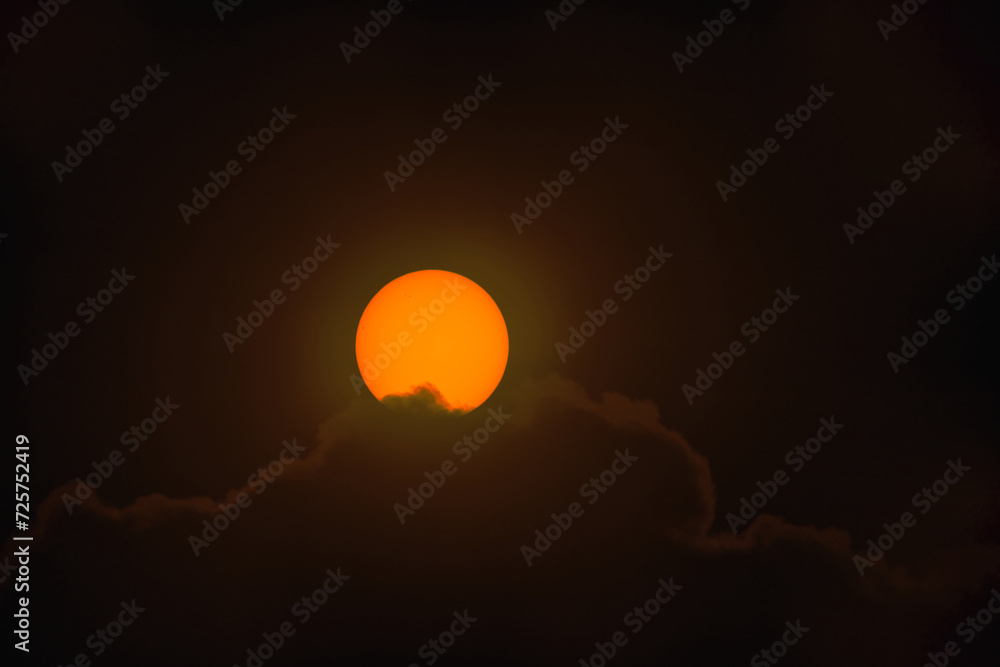Tarcza słoneczna sfotografowana z użyciem teleobiektywu. W wyniku zastosowania filtra optycznego uzyskano ciepłą barwę tarczy słonecznej. Widoczne są plamy na powierzchni słońca.  - obrazy, fototapety, plakaty 