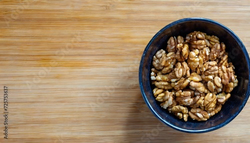 a bowl of peeled walnut kernels on a wooden board with copy space