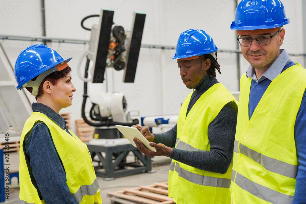 Multiracial engineer people working inside robotic factory while using digital tablet - Augmented technology and innovation concept Multiracial engineer people working inside robotic factory while using digital tablet - Augmented technology and innovation concept