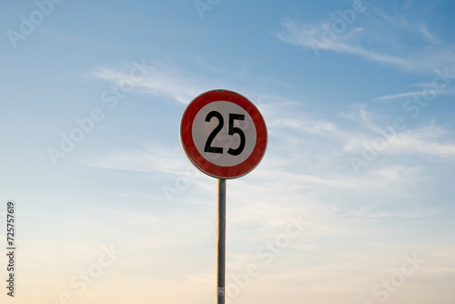 25 miles km maximum speed limit traffic sign isolated with sunset sky