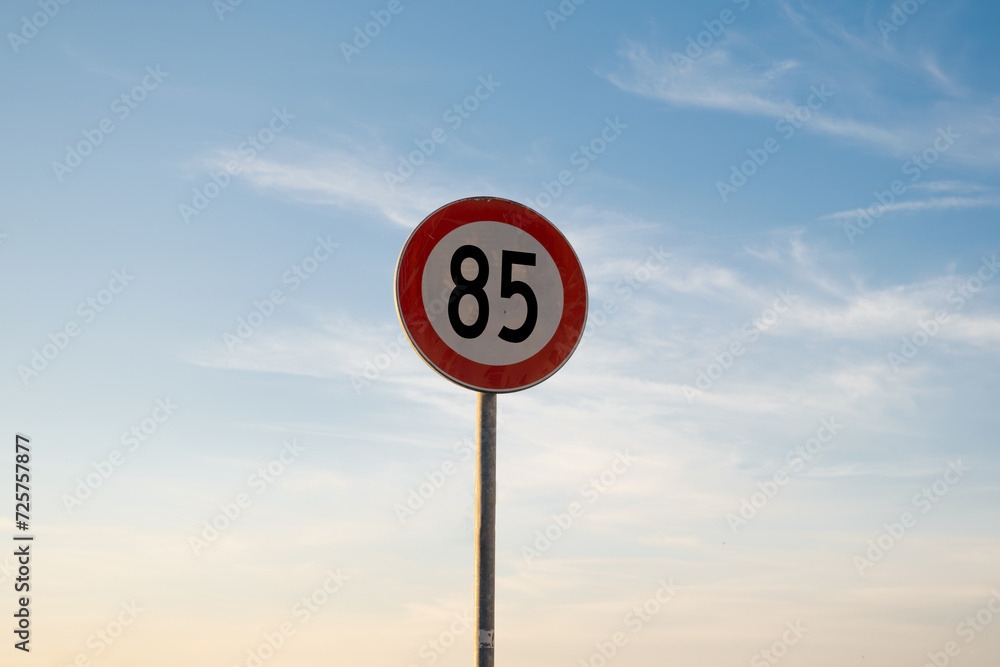 85 miles km maximum speed limit traffic sign isolated with sunset sky