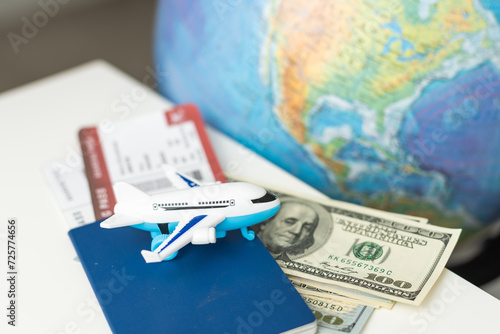 Toy airplane, globe and passport on a blue background