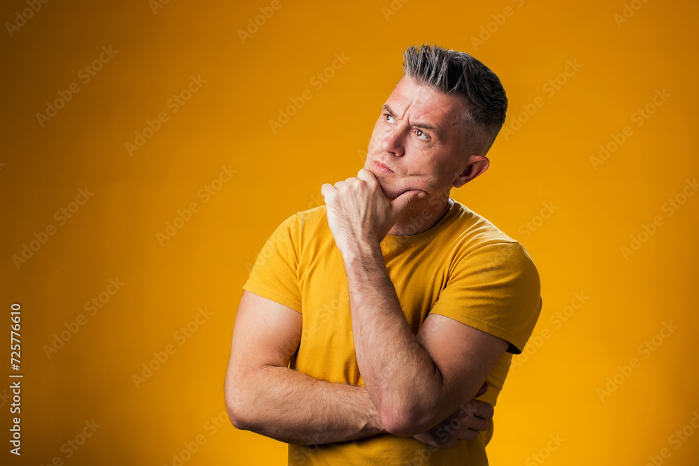 Man with hand on chin thinking about question, pensive expression. People and emotion concept Man with hand on chin thinking about question, pensive expression. People and emotion concept