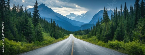 an asphalt road winding through a lush green forest against the backdrop of majestic mountains, showcasing the serene harmony of the natural landscape.