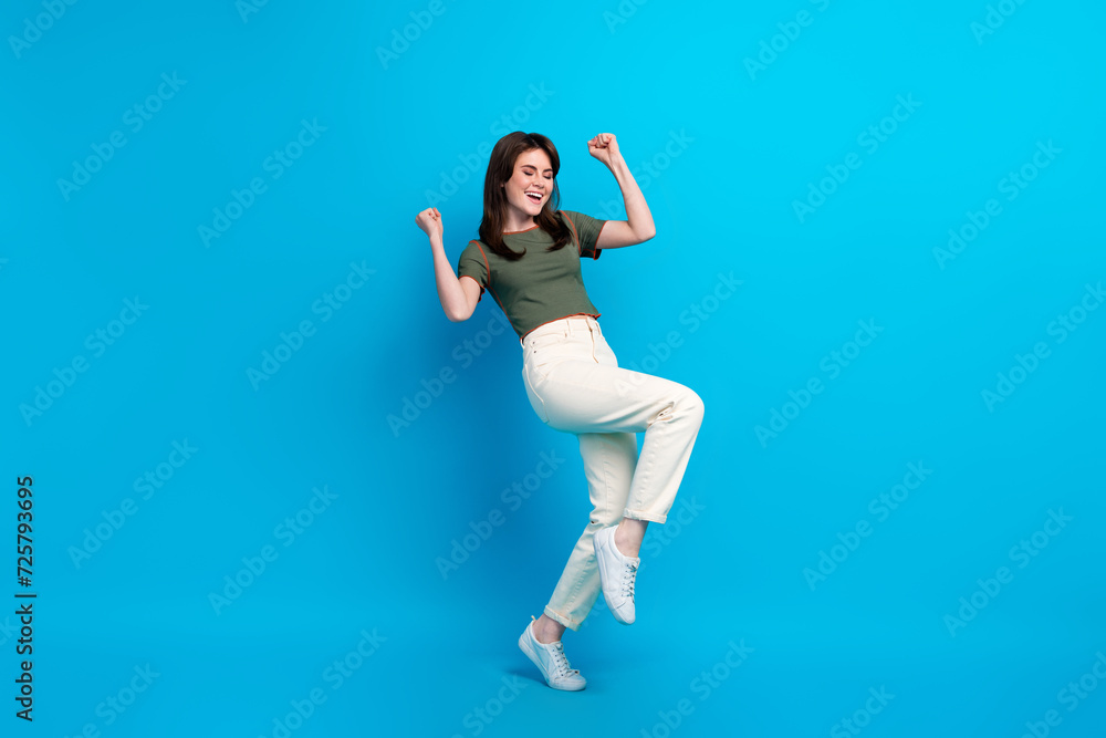 Obraz premium Full size photo of glad delighted girl raise fists shout yes success achieve isolated on blue color background