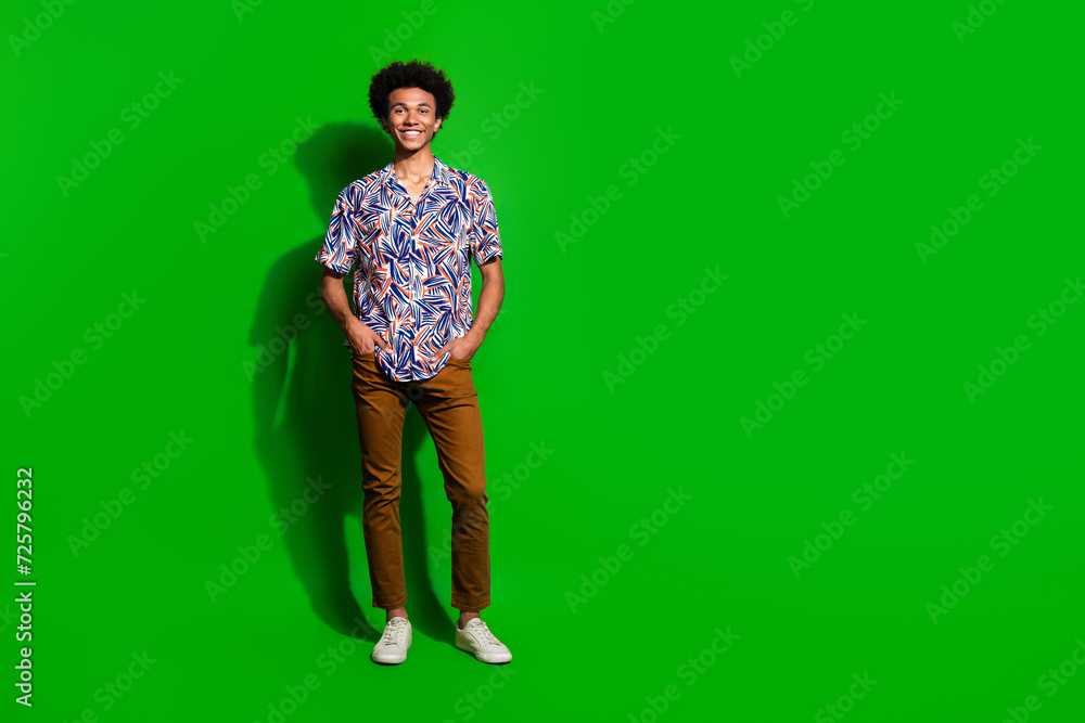 Full size body photo of young boyfriend standing in studio wearing casual summer outfit near mockup isolated on green color background Full size body photo of young boyfriend standing in studio wearing casual summer outfit near mockup isolated on green color background