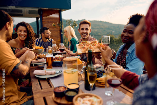Canvas Print Cheerful friends enjoying in meal at dinning table on patio.
