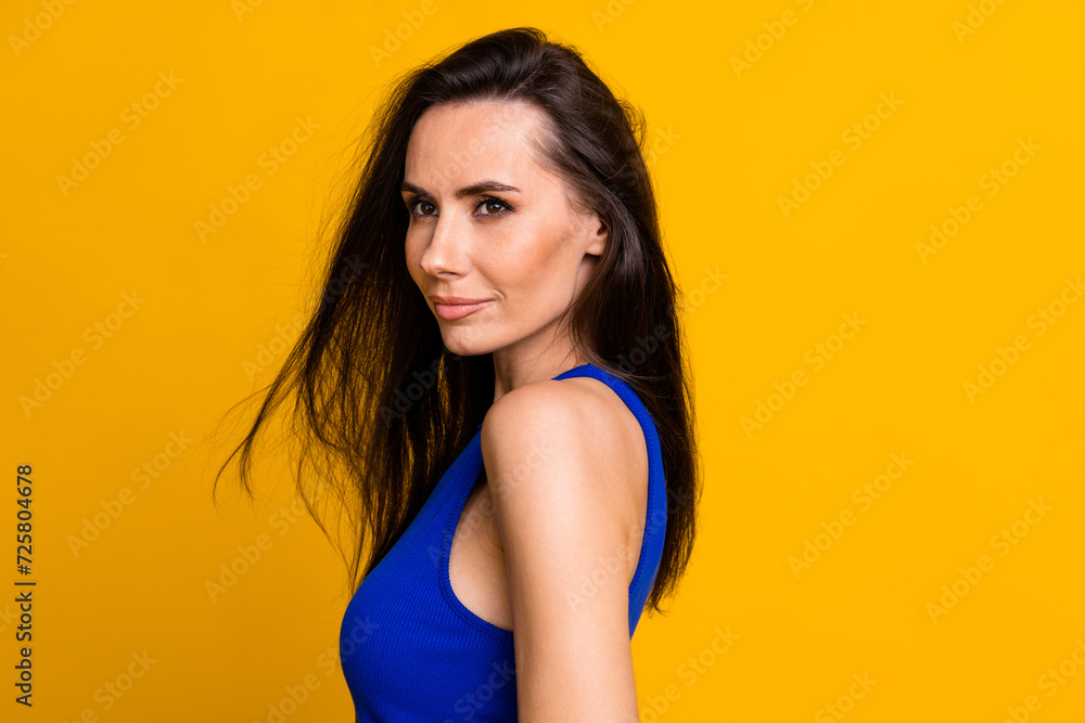 Photo of adorable shiny lady dressed blue top smiling empty space isolated yellow color background Photo of adorable shiny lady dressed blue top smiling empty space isolated yellow color background