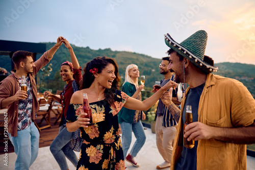 Carefree woman has fun while dancing with friends on summer party outdoors.
