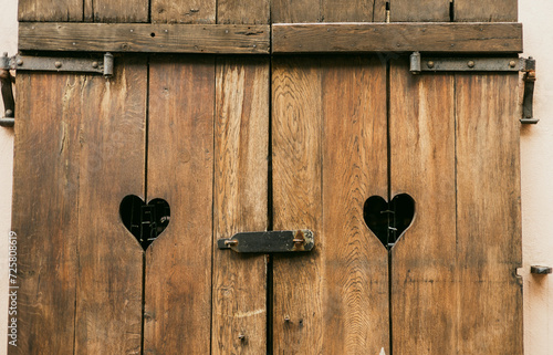 Old wooden Window shutters with hearts. Sad Valentine, lost love, love end, relations crisis, relationship problem metaphor concept. Grungy romance background.