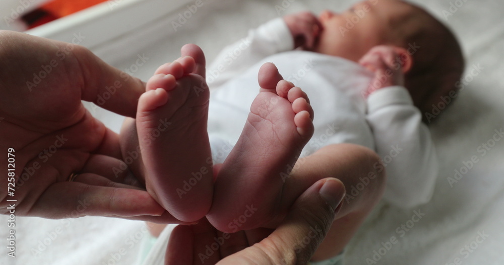 Showing newborn baby feet holding infant foot Showing newborn baby feet holding infant foot