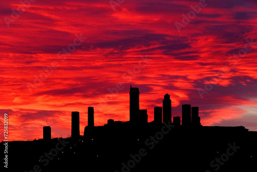 Silhouette of the towers of San Gimignano in front of dramatic red clouds at sunset, Tuscany, Italy, Europe