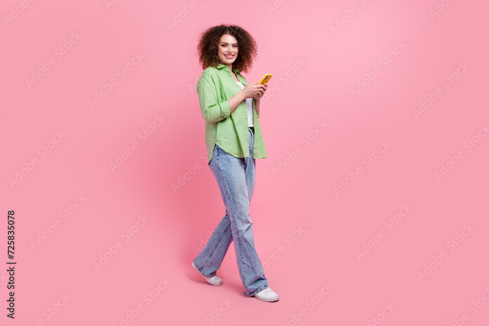 Full length body photo of positive office woman manager control processes in online using cellphone isolated over pink color background Full length body photo of positive office woman manager control processes in online using cellphone isolated over pink color background