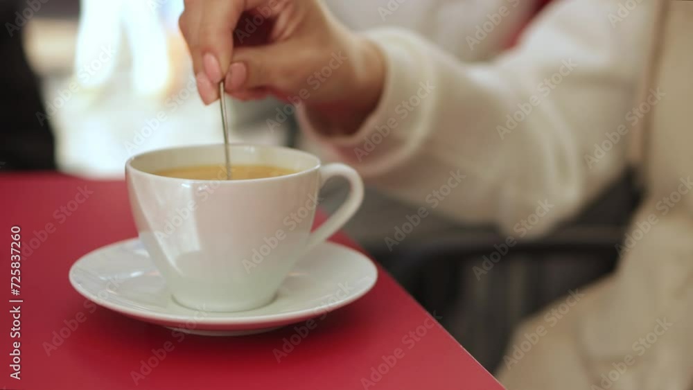 a girl sitting in a cafe stirs a cup of hot coffee. Fresh morning coffee close-up. Cappuccino latte a girl sitting in a cafe stirs a cup of hot coffee. Fresh morning coffee close-up. Cappuccino latte