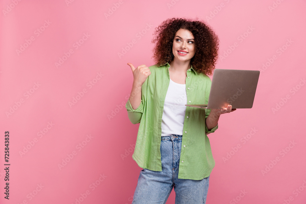 Photo portrait of lovely young lady netbook point look empty space wear trendy green garment isolated on pink color background Photo portrait of lovely young lady netbook point look empty space wear trendy green garment isolated on pink color background