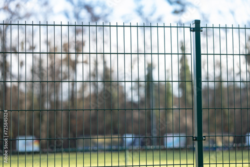 Metalowe Ogrodzenie z Rozmytym Krajobrazem Parkowym w Tle