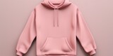 A pink hoodie is hanging on a wall. Suitable for fashion and clothing-related projects