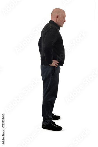 side view of a standing , serious and arms akimbo man on white background