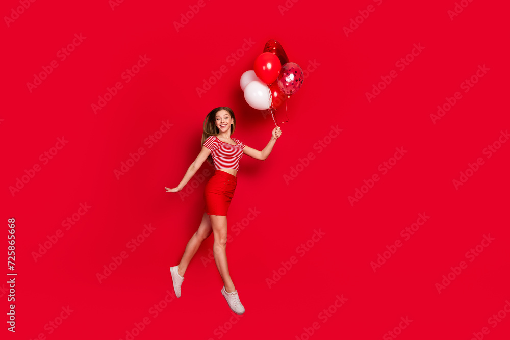 Full length photo of sweet pretty lady dressed striped top enjoying birthday party flying balloons empty space isolated red color background - obrazy, fototapety, plakaty 