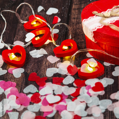 Wooden background with red hearts, gifts and garland. Valentine's Day concept.