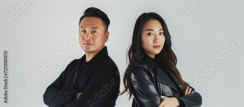 Asian man and woman confidently pose on a white background.