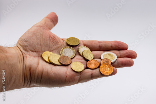 Money in the form of euro coins slips through the fingers during the crisis and inflation