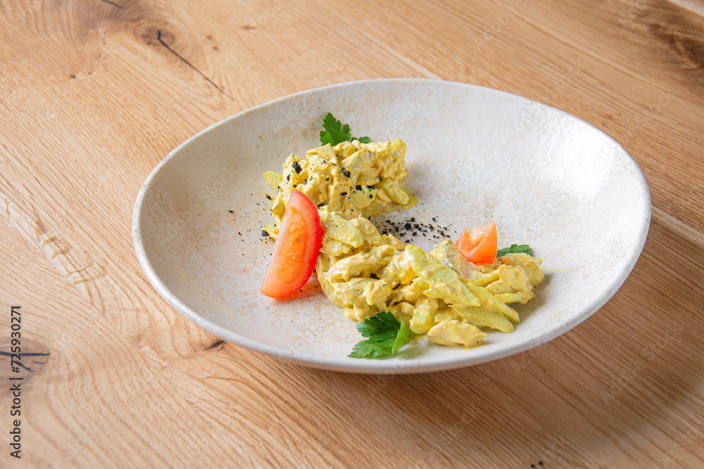 Scrambled omelette with tomato slices on a white plate Scrambled omelette with tomato slices on a white plate