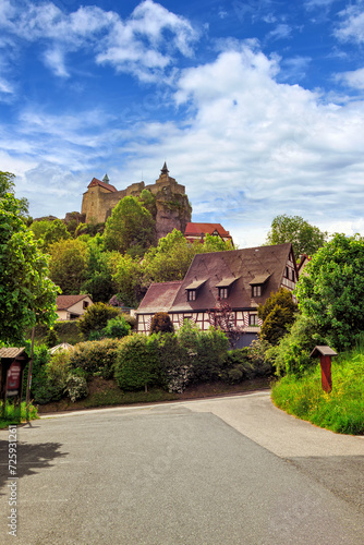 Anblick der Burg Hohenstein mit alten Fachwerkhäusern in Mittelfranken, Bayern, Deutschland vor weiß-blauem Himmel