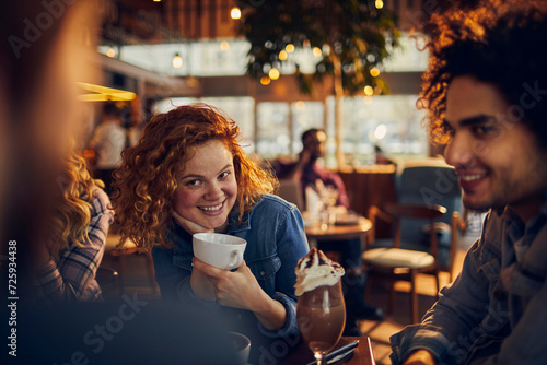 Young diverse group of people having coffee in a cafe photo