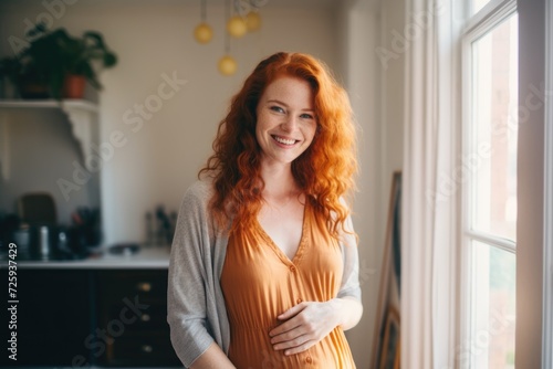 Smiling portrait of a young pregnant woman at home