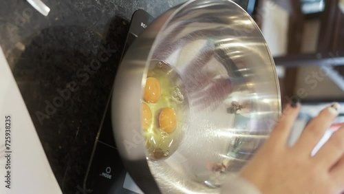 Experienced pastry chef skillfully cracking fresh eggs into a bowl with finesse, capturing the essence of culinary mastery, vertical video 