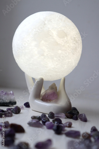 Amethyst crystals and moon in ceramic hand.
