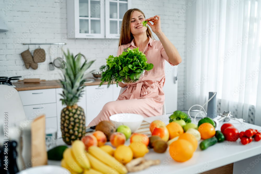 Young woman sitting on the table with healthy food in the kitchen Young woman sitting on the table with healthy food in the kitchen