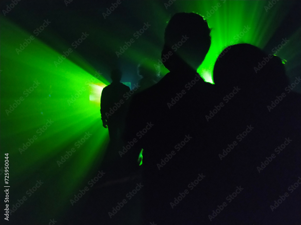 silueta de personas detrás de luz verde
