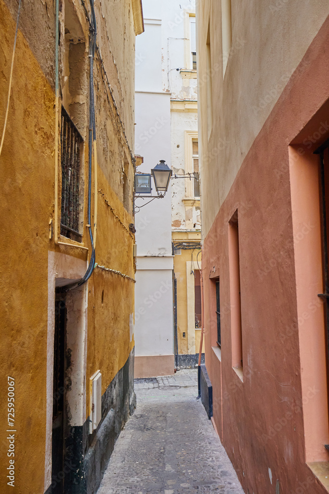 Obraz premium Narrow street with stone pavement in the old center of Sevilla, Spain.