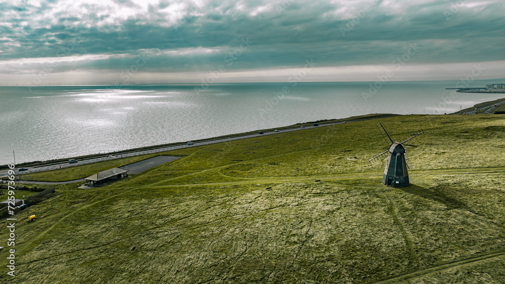Fototapeta premium Aerial view if an old windmill on the top of the cliff by the sea, Rottingdean, Brighton, East Sussex, UK
