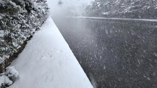 Walking into heavy snow by waterway in white winter landscape