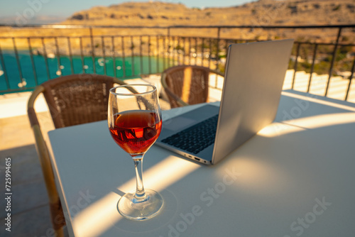 Laptop and a glass of wine. An ideal place for remote work. © M-Production