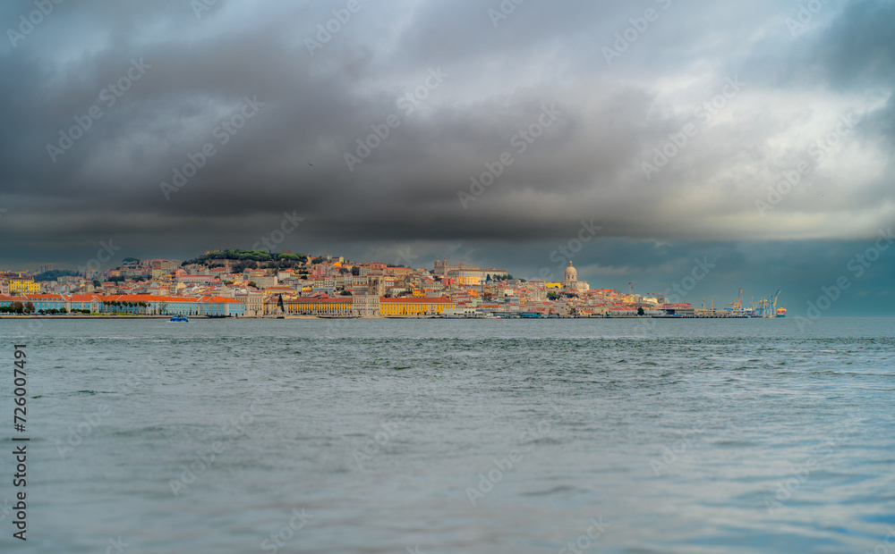 A panoramic perspective of Lisbon. The sea in the foreground. cloudy sky.