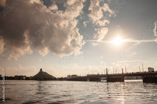 Panorama of the daugava river in riga, latvia, during a sunny sunset with the Akmens tils, Riga Stone bridge in background. Riga is the capital city of Latvia, in the baltic countries. photo