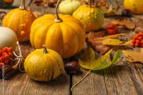 Composition with pumpkins and autumn leaves on brown wooden background