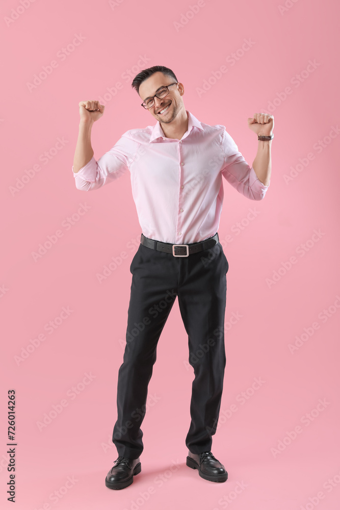 Happy young businessman on pink background Happy young businessman on pink background
