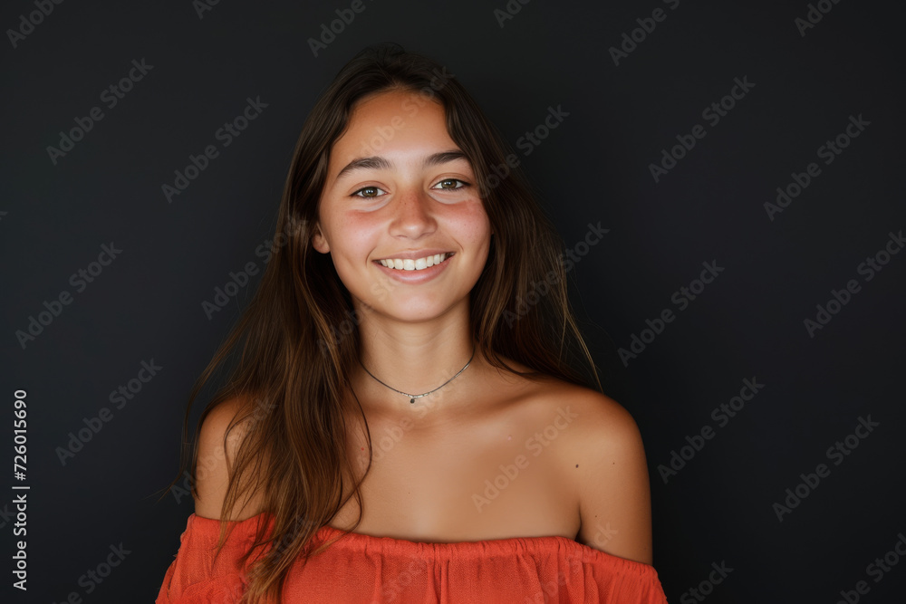 A woman wearing a red off the shoulder top smiles for the camera A woman wearing a red off the shoulder top smiles for the camera
