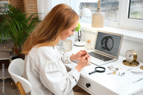 Female jeweler examining ri...