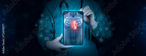 The doctor analyzes the cardiac angiography. Doctor with tablet shows chest x-ray. The human heart is observed focused. Technological digital background photo