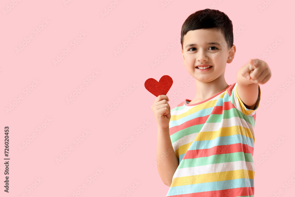 Cute little boy with heart pointing at viewer on pink background. Valentine's Day celebration Cute little boy with heart pointing at viewer on pink background. Valentine's Day celebration
